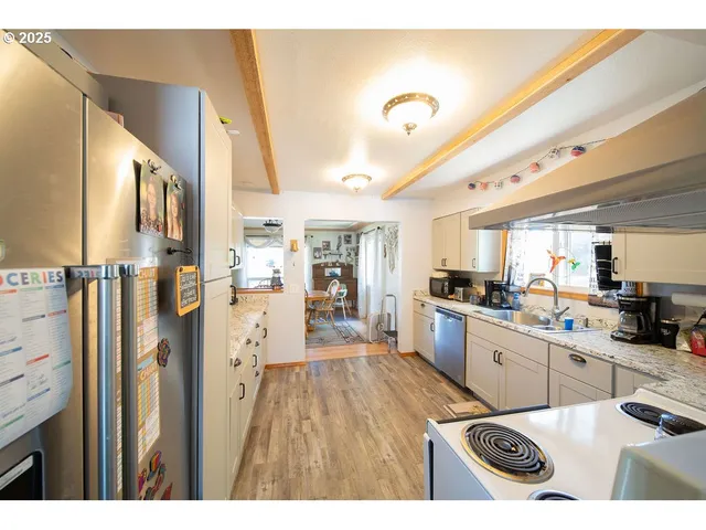 a kitchen with stainless steel appliances kitchen island granite countertop a refrigerator and a stove top oven