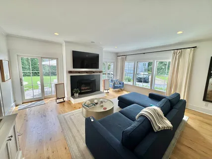 a living room with furniture a flat screen tv and a fireplace