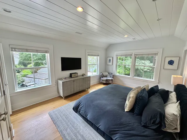 a living room with a bed furniture and a flat tv screen