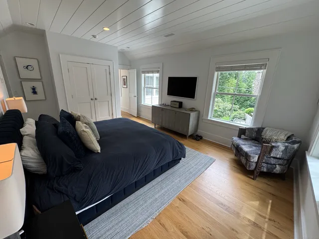 a bedroom with furniture and a flat screen tv