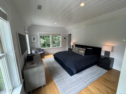 a bedroom with a bed a couch and a large window