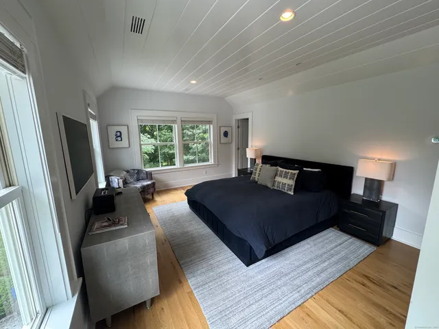 a bedroom with a bed a couch and a large window