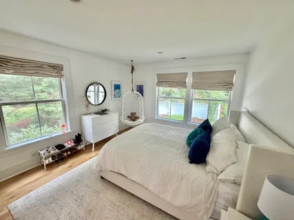 a large bed sitting in a bedroom next to a window