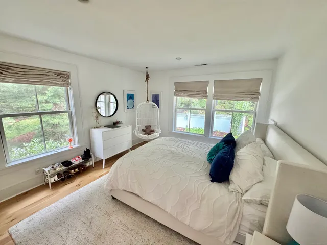 a large bed sitting in a bedroom next to a window