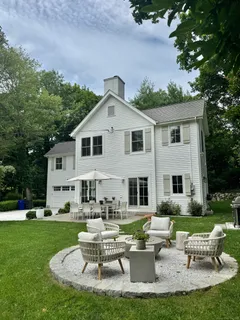a front view of a house with a yard table and chairs