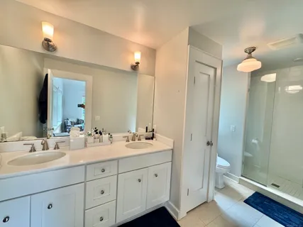 a bathroom with a double vanity sink toilet and shower