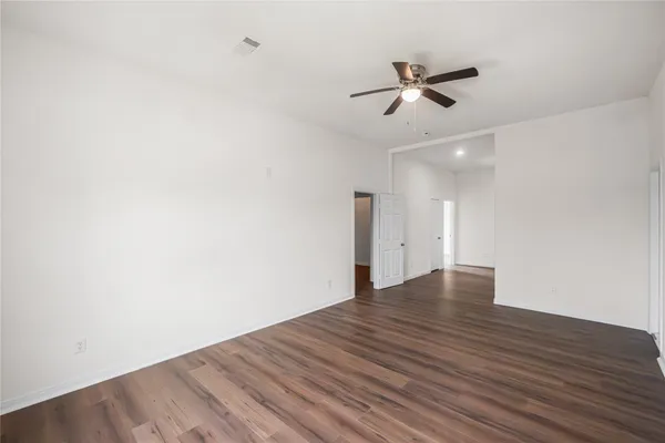 a view of empty room with wooden floor