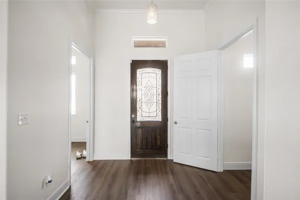 an empty room with wooden floor closet and windows