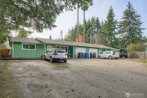 a front view of a house with a garden and trees