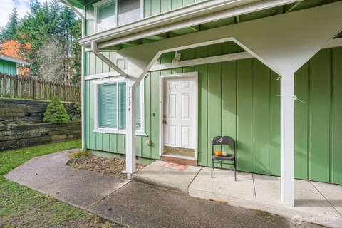 a view of a house with a small yard and wooden fence