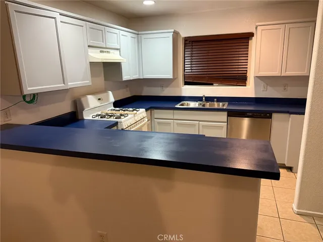 a kitchen with stainless steel appliances a sink cabinets and a window