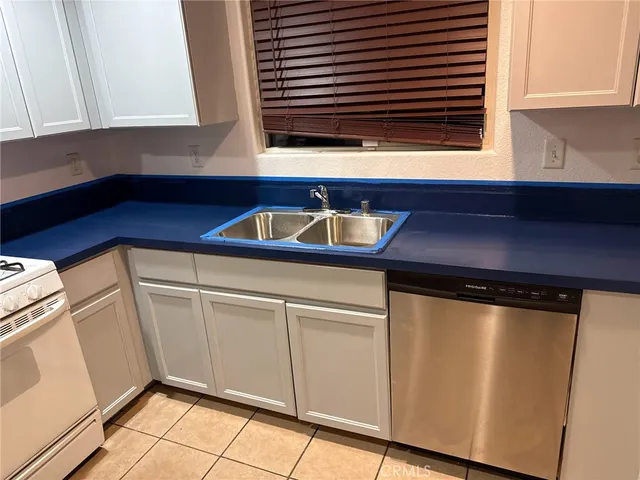 a kitchen with a sink a refrigerator and cabinets