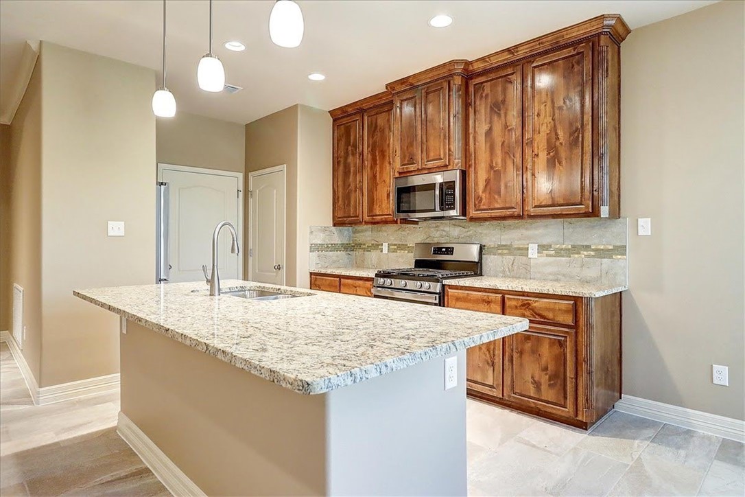 3153 Seawolf Corpus Christi, TX 78414 - Photo 15 of 40 a kitchen with kitchen island granite countertop a stove sink and cabinets
