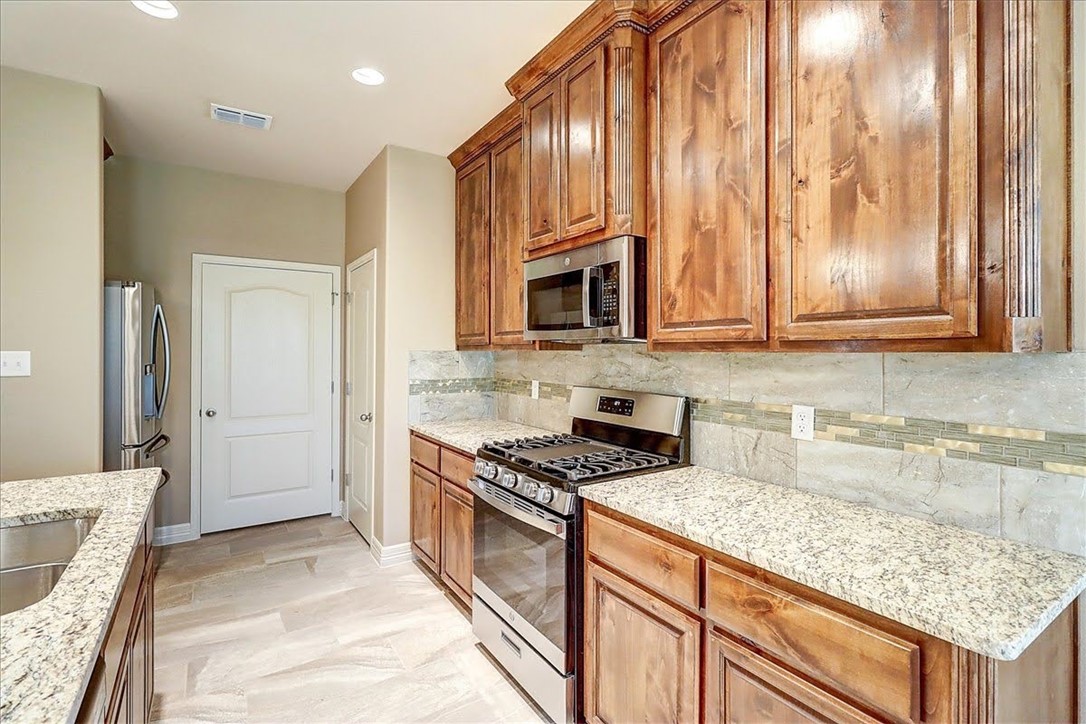 3153 Seawolf Corpus Christi, TX 78414 - Photo 16 of 40 a kitchen with granite countertop cabinets stainless steel appliances a sink and a counter space