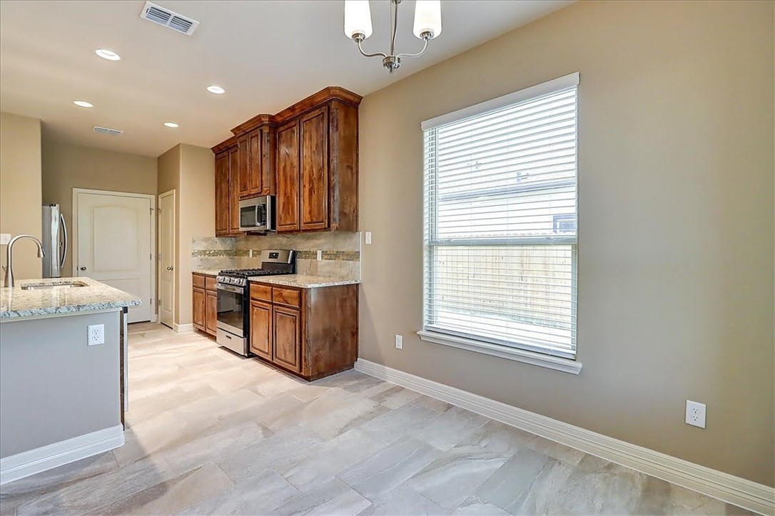 3153 Seawolf Corpus Christi, TX 78414 - Photo 21 of 40 a kitchen with stainless steel appliances granite countertop a stove a sink and a microwave