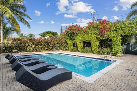 a view of a house with swimming pool and sitting area