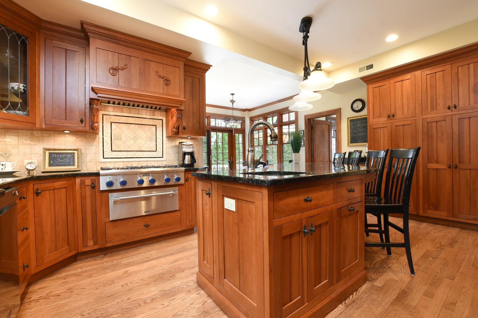 95 Michaux Road Riverside, IL 60546 - Photo 15 of 48 a kitchen with stainless steel appliances granite countertop wooden cabinets a stove a sink a dining table and chairs