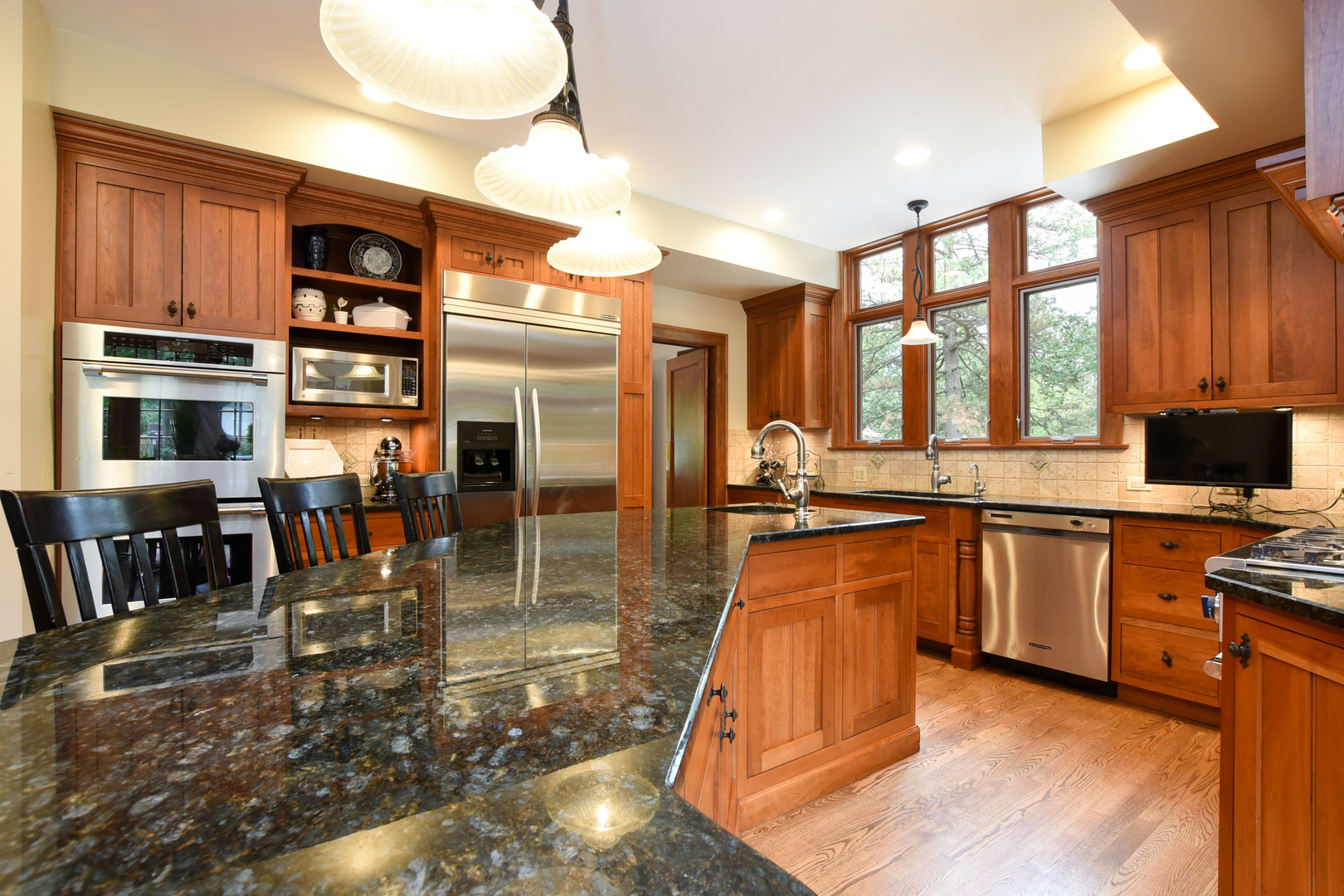 95 Michaux Road Riverside, IL 60546 - Photo 17 of 48 a kitchen with stainless steel appliances granite countertop a stove top oven a sink a dining table and chairs with wooden floor