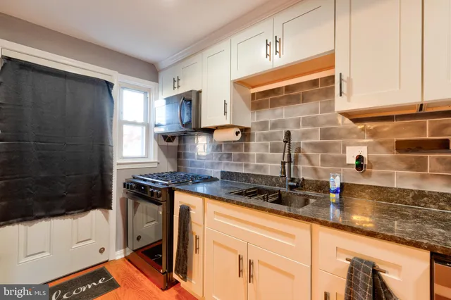 a kitchen with stainless steel appliances granite countertop a sink stove and cabinets