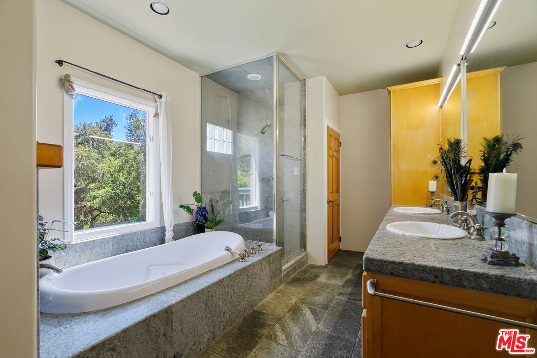 20912 Fontaine Road Topanga, CA 90290 - Photo 22 of 52 a spacious bathroom with a granite countertop tub sink a mirror and a shower
