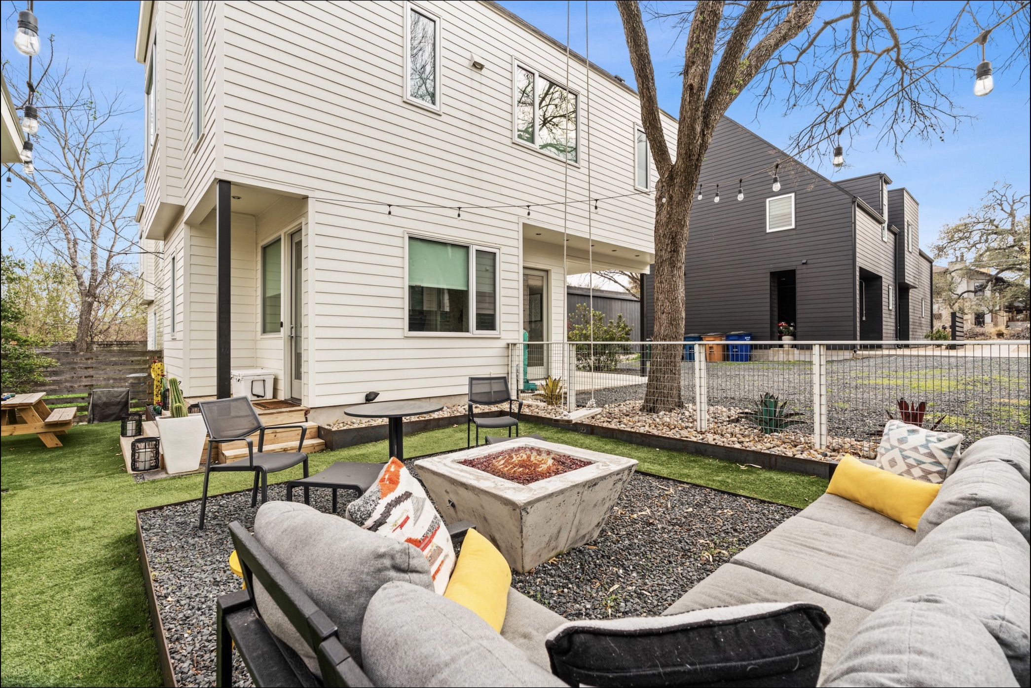 1608 Ravey Street, Unit B Austin, TX 78704 - Photo 10 of 25 Rear view of property with a patio area, an outdoor living space with a fire pit, and a fenced backyard