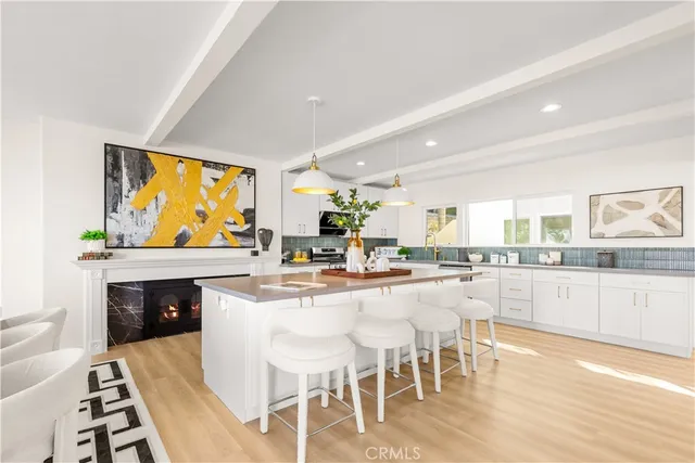 a kitchen with stainless steel appliances granite countertop a stove top oven a sink a dining table and chairs