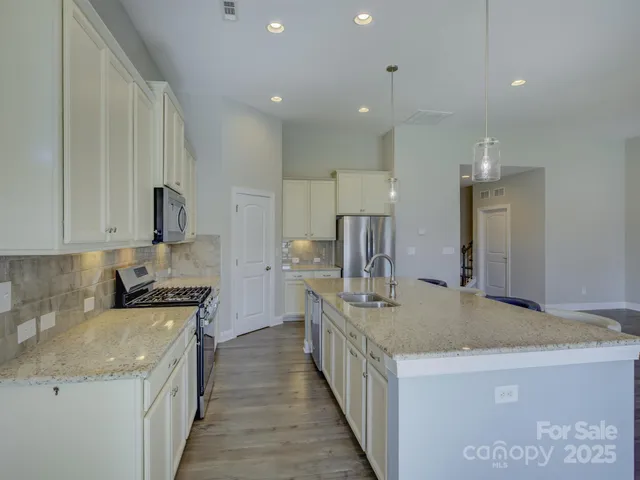 a kitchen with granite countertop a stove and a sink
