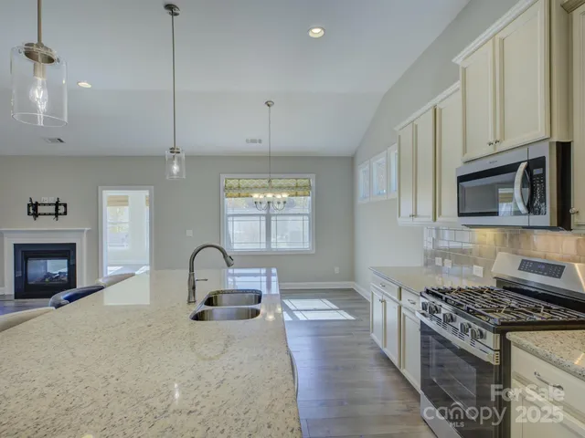 a kitchen with stainless steel appliances granite countertop a stove and a microwave