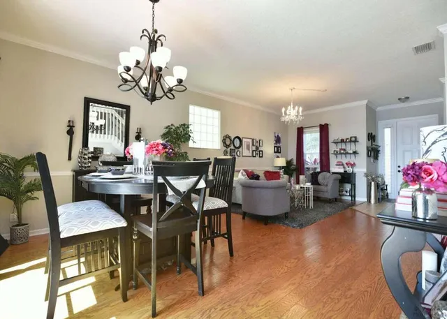 a view of a dining room with furniture and a chandelier