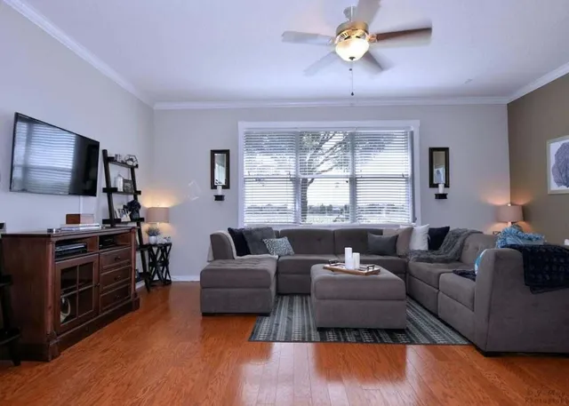 a living room with furniture a flat screen tv and a large window