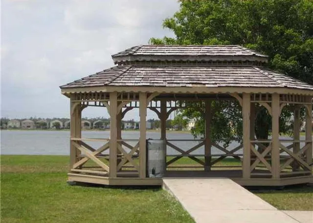 a view of a chairs and table in the patio next to a yard