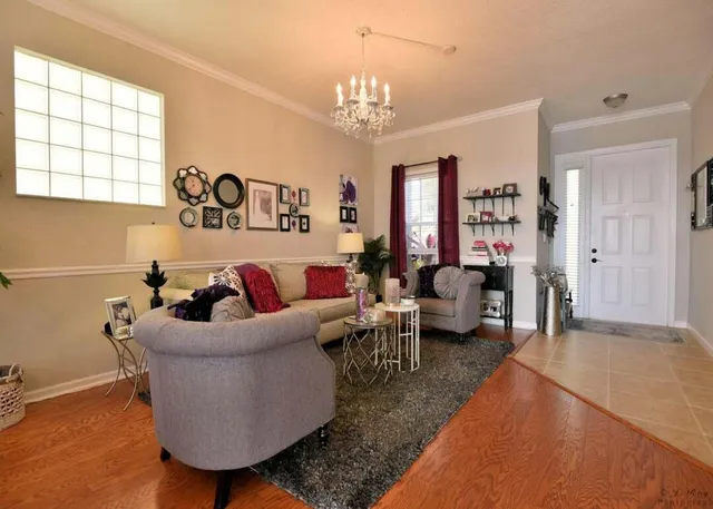 a living room with furniture and a chandelier