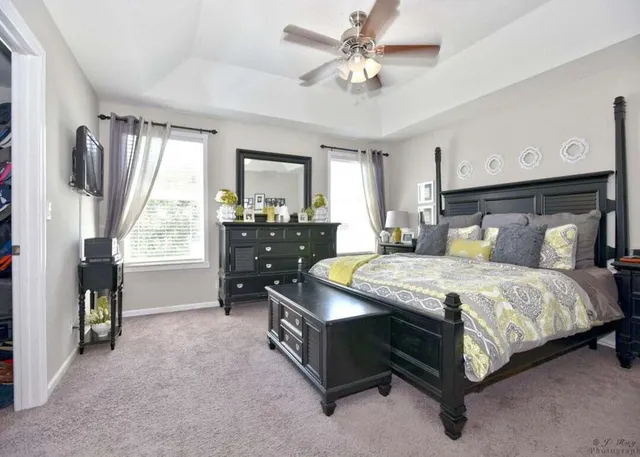 a bedroom with a bed a dresser next to a window