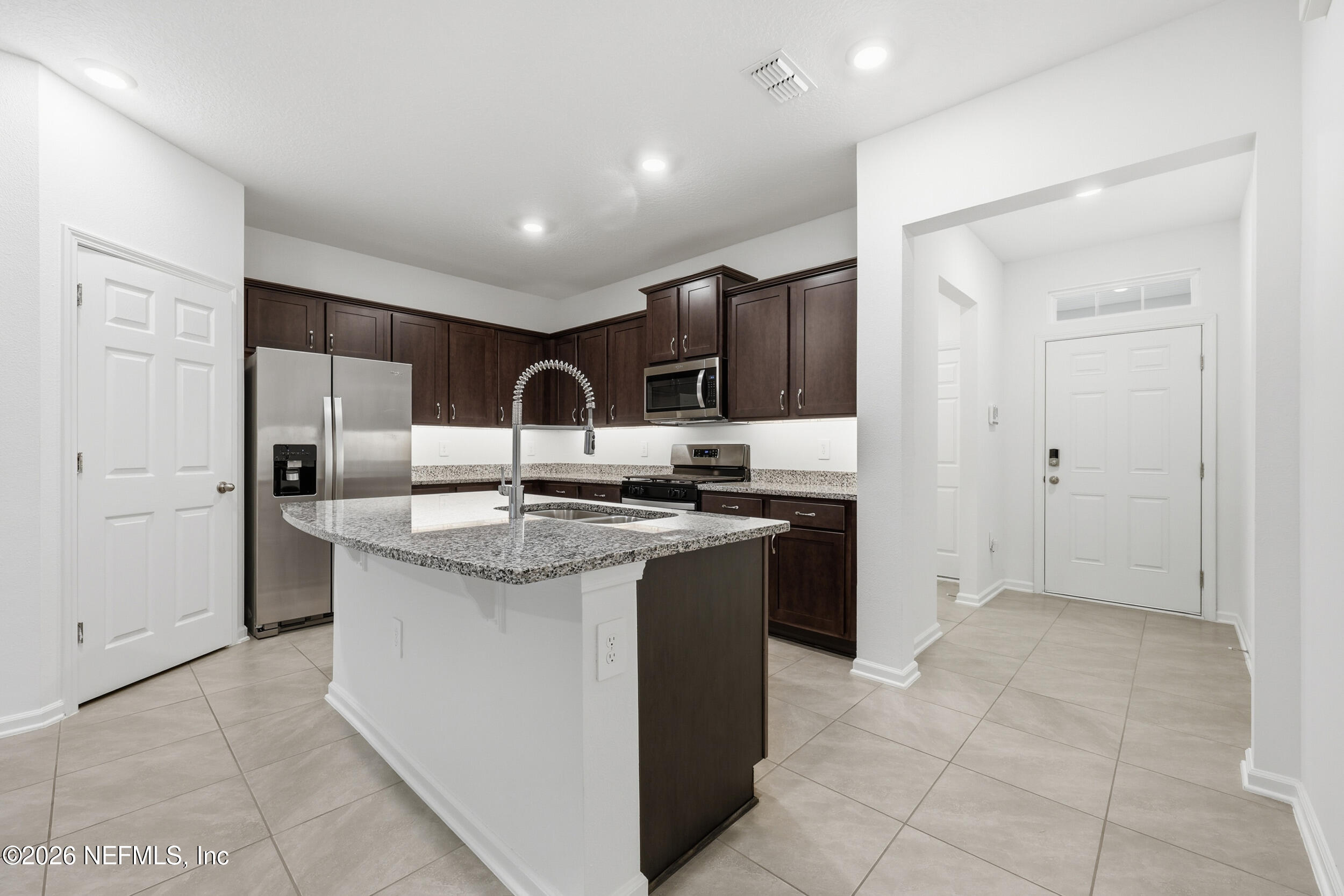 70 Barley Street St. Augustine, FL 32092 - Photo 6 of 40 a kitchen with kitchen island granite countertop a sink and a refrigerator