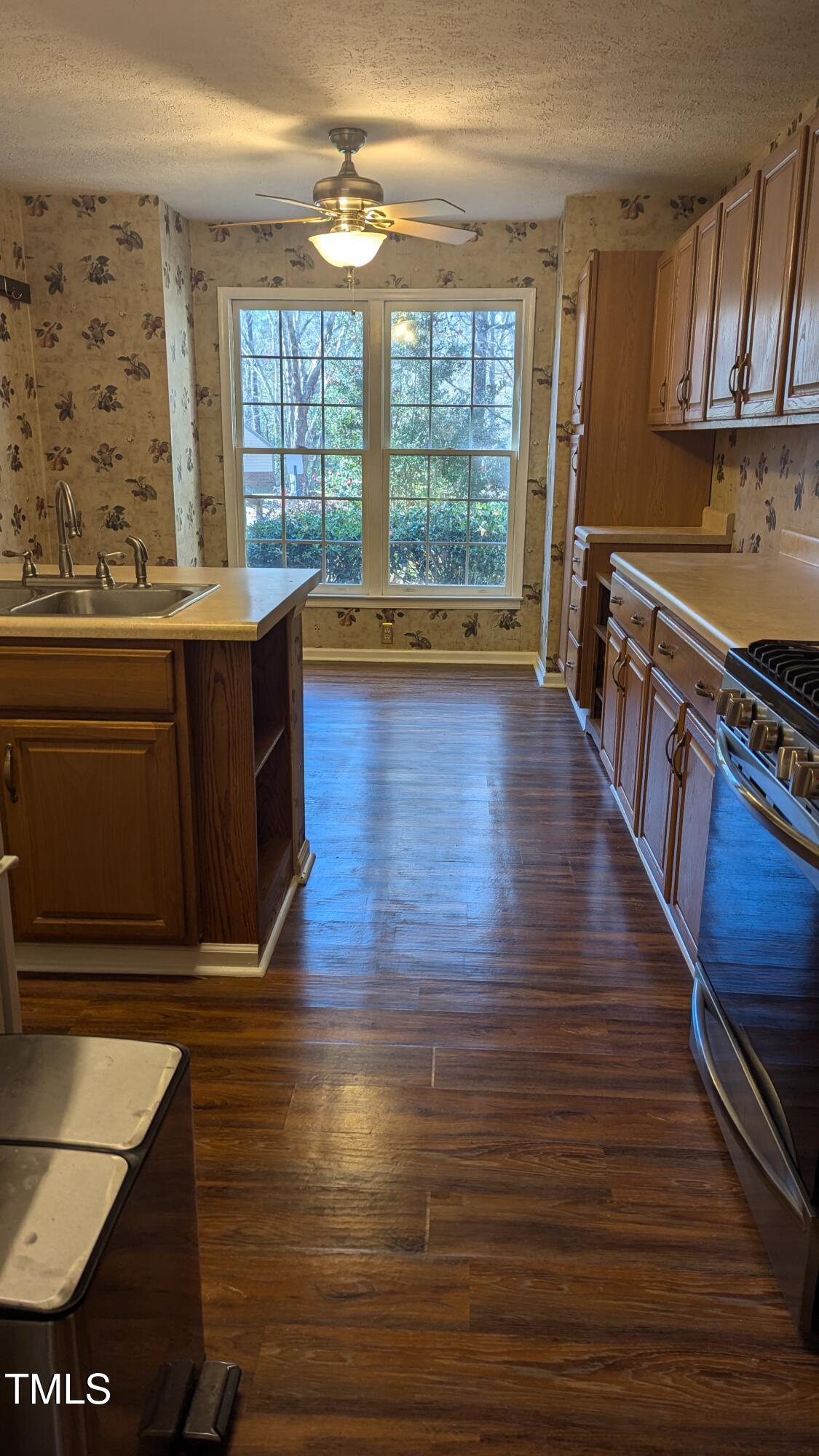 105 Broad Leaf Circle Raleigh, NC 27613 - Photo 6 of 19 a kitchen with wooden floors and a black wooden cabinets