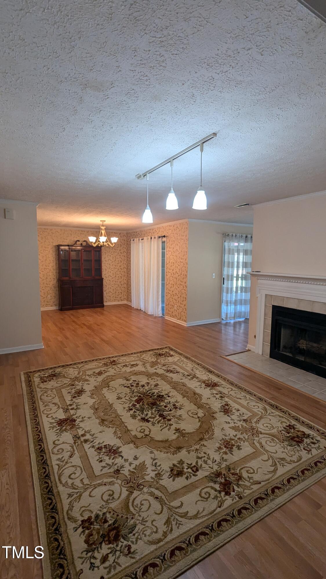 105 Broad Leaf Circle Raleigh, NC 27613 - Photo 8 of 19 an empty room with wooden floor fireplace and windows
