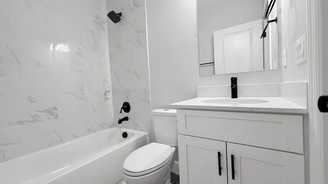 a bathroom with a sink a toilet and shower