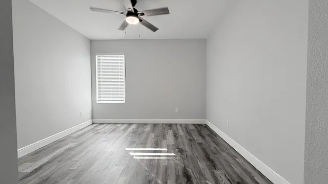 wooden floor in an empty room with a window