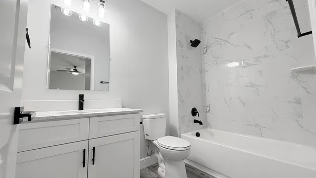 a bathroom with a sink a toilet and shower