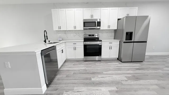 a kitchen with stainless steel appliances a refrigerator stove and microwave