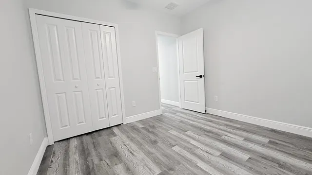 a view of an empty room with wooden floor