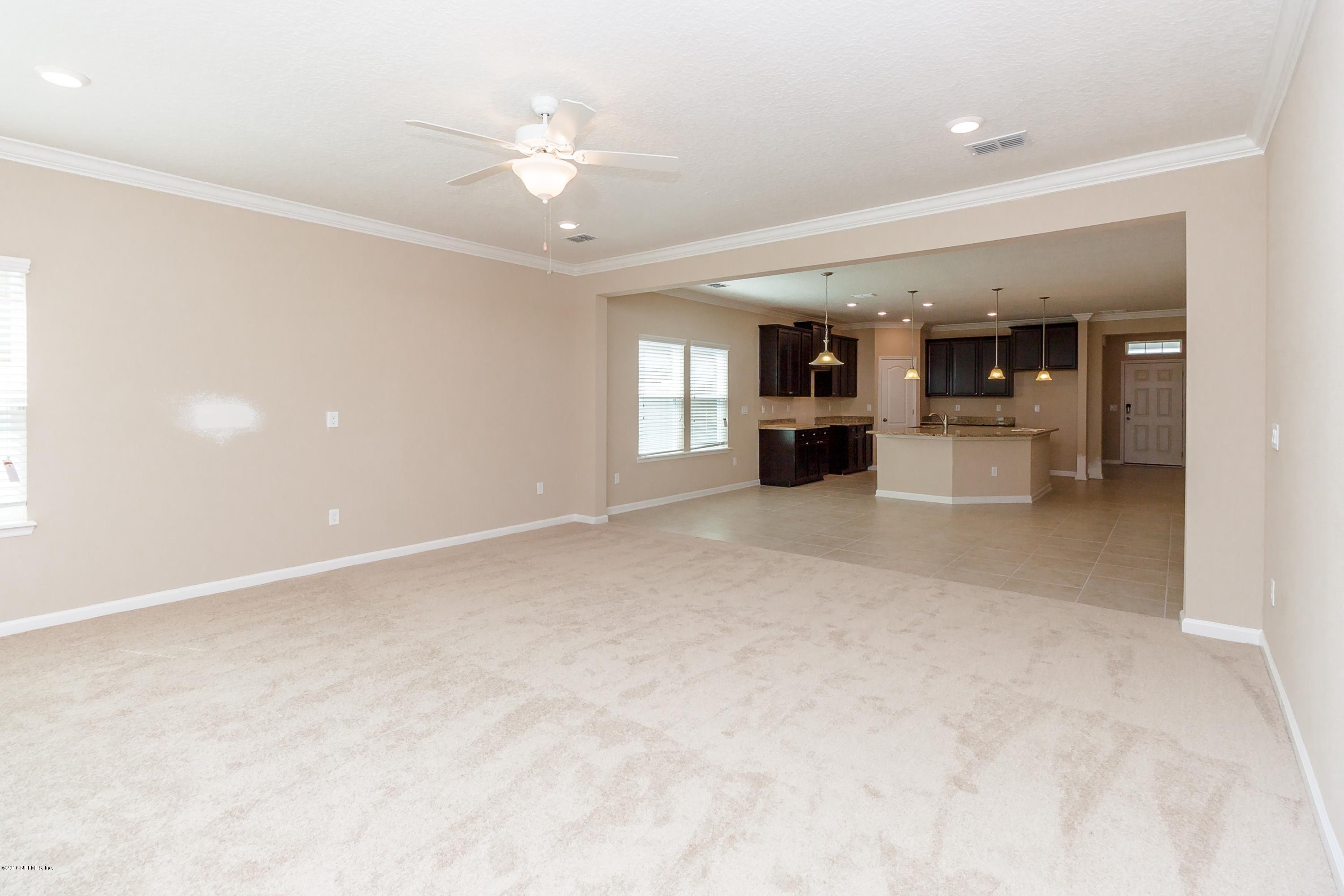 15714 Tisons Bluff Road Jacksonville, FL 32218 - Photo 24 of 44 an empty room with a kitchen and chandelier fan