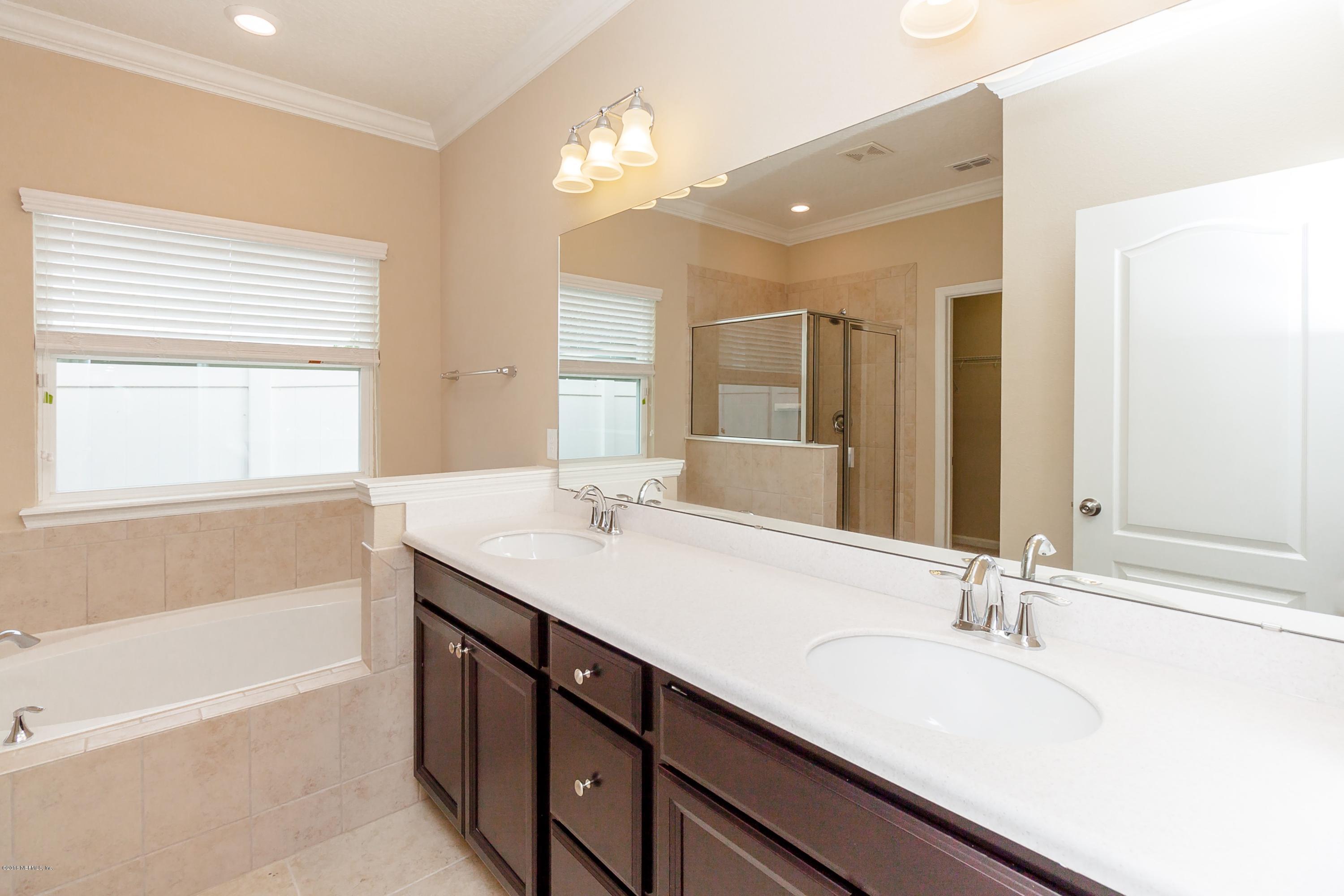 15714 Tisons Bluff Road Jacksonville, FL 32218 - Photo 28 of 44 a bathroom with a sink double vanity granite tub shower and a mirror