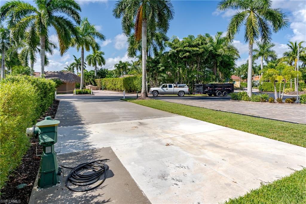 13611 Snook Circle Naples, FL 34114 - Photo 29 of 47 a view of a backyard with a fountain plants and palm trees