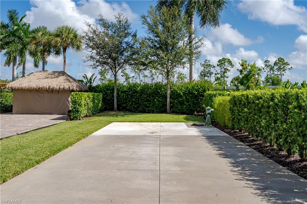 13611 Snook Circle Naples, FL 34114 - Photo 9 of 47 front view of a house with a yard and potted plants