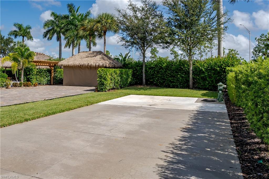 13611 Snook Circle Naples, FL 34114 - Photo 10 of 47 a view of a backyard with potted plants and palm trees
