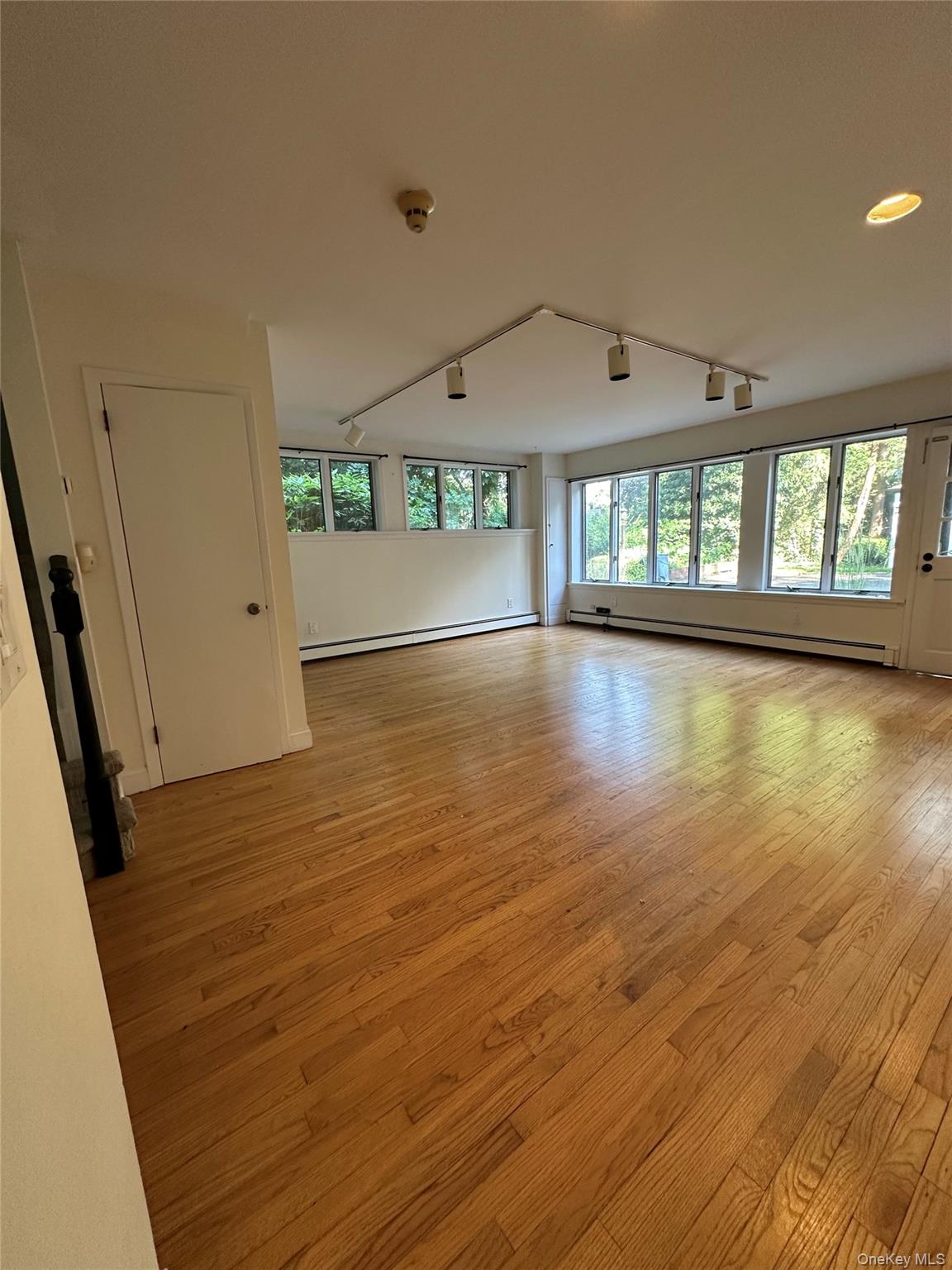 5 Beverly Road Port Washington, NY 11050 - Photo 7 of 10 an empty room with wooden floor and windows