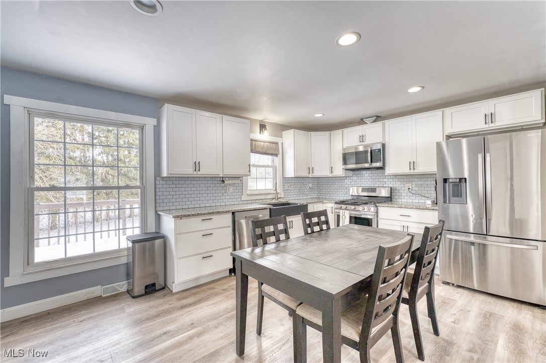 6160 Dresden Road Zanesville, OH 43701 - Photo 11 of 32 Kitchen with stainless steel appliances, backsplash, white cabinets, light stone countertops, and recessed lighting