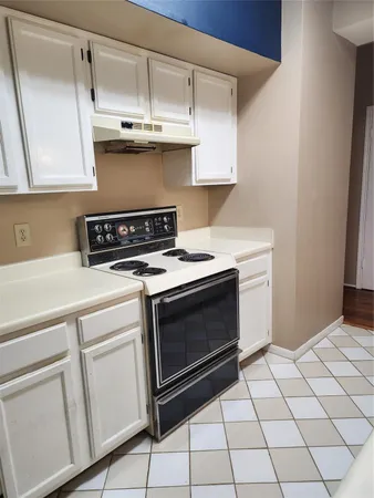 a kitchen with white cabinets and appliances