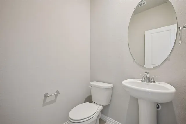 a bathroom with a toilet a sink and a mirror